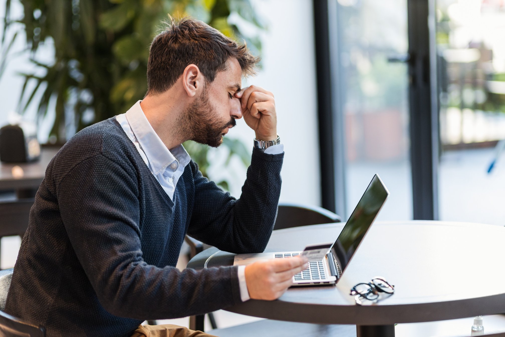 Young man stressed about lack of money on his bank account